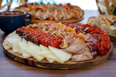 A platter of traditional meats, cheeses and dried fruits served at a market gathering