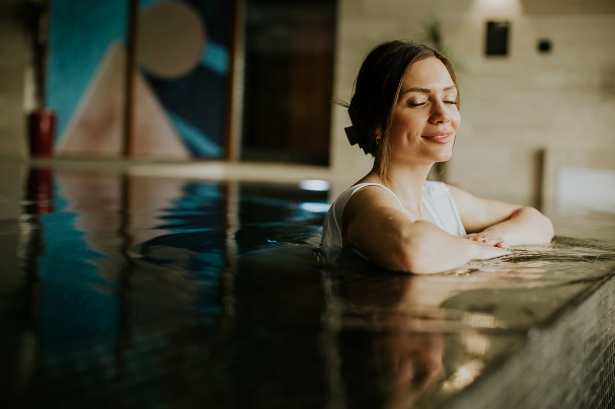 Relaxing indoor pool and tropical wellness area at a modern spa complex