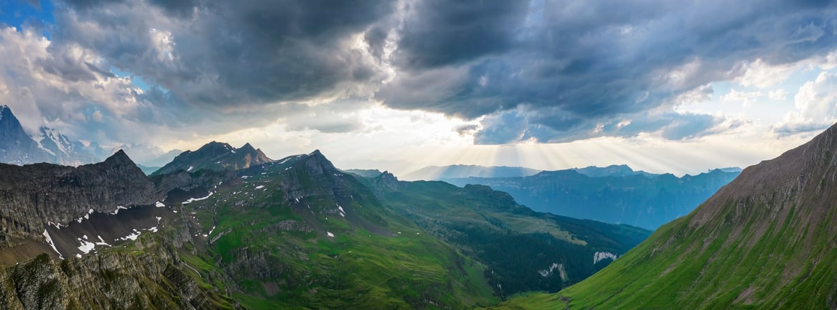 Alpine valley panorama with mountain peaks at golden hour