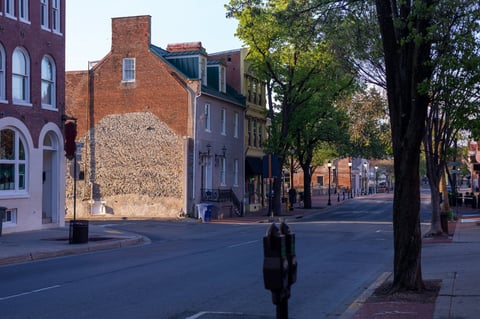 A serene view of historic brick buildings and empty sidewalks in an old neighbourhood with long morning shadows