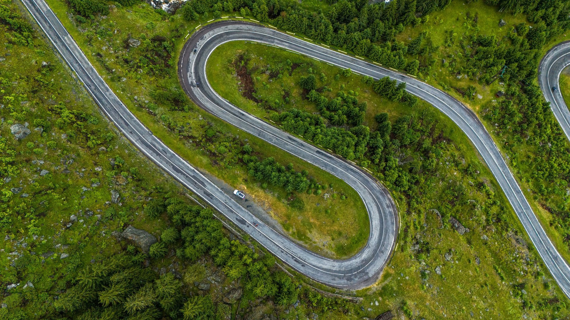 Aerial drone view of the hairpin curves of the Transfagaras Road (DN7C) winding through the Fagaras Mountains in Romania