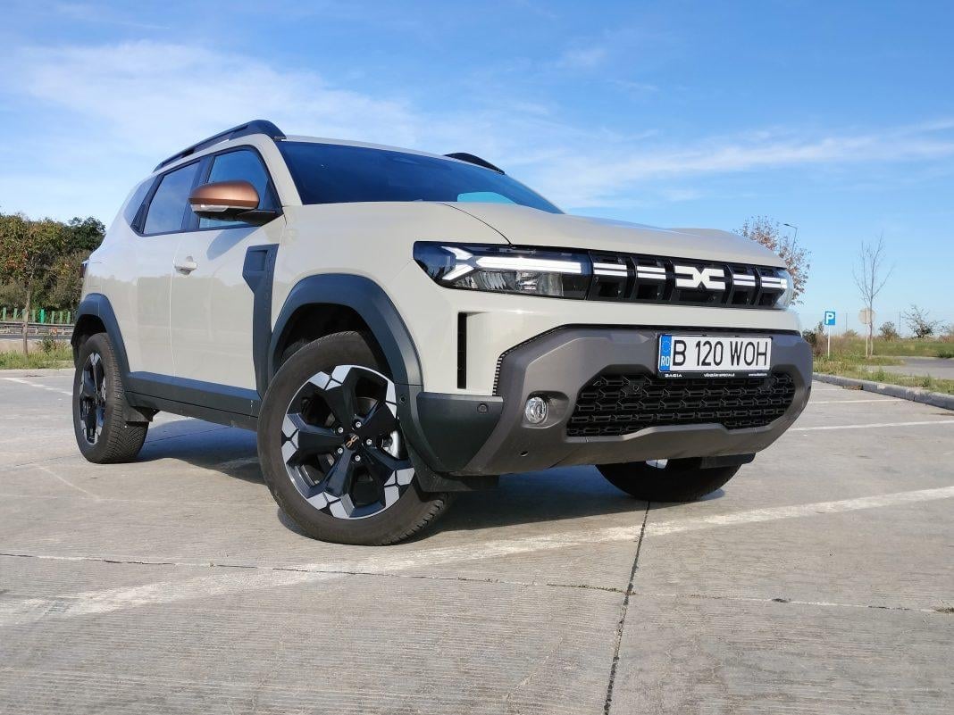 White and blue Dacia Duster compact SUV parked on asphalt with clear sky background