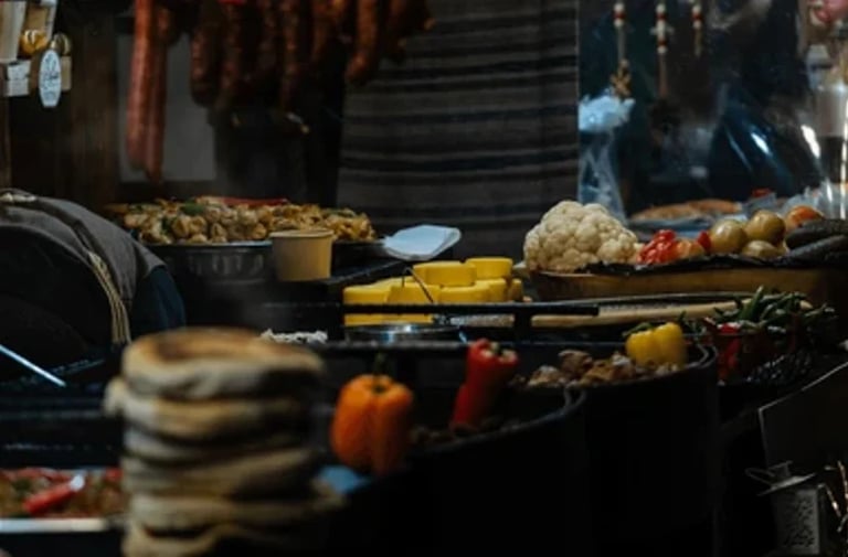Street food cooking scene with grilled vegetables, skewers, and various dishes on a dark cooking surface at night