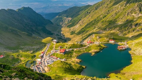 Mountain dam with reservoir water surrounded by alpine peaks