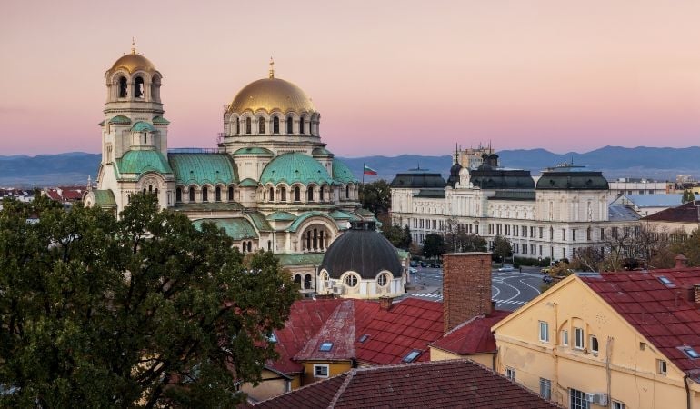 Alexander Nevsky Cathedral with golden domes in Sofia, Bulgaria during sunset, overlooking the city skyline