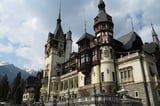 Neuschwanstein Castle, a large ornate Romanesque Revival castle with multiple towers and turrets set against a mountainous backdrop